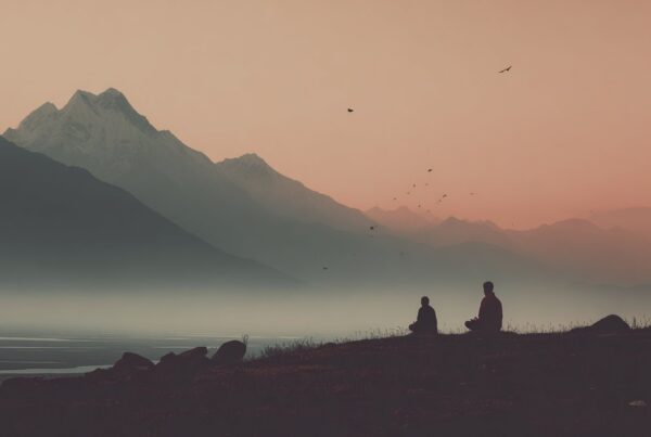 Two people meditate at sunrise in front of snow-capped mountains, reflecting the Secrets of Tantric Energy in stillness and nature.